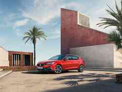 Ein roter Seat Leon parkt vor einem Gebäude.